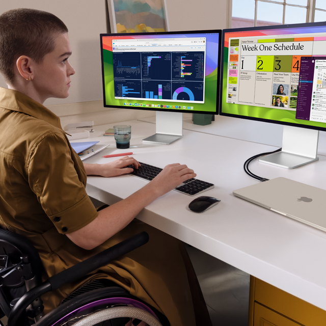 Uma pessoa trabalha com dois monitores externos conectados a um MacBook Air de 15 polegadas fechado na cor estelar