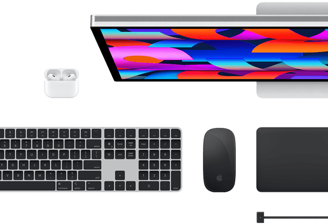 Imagem de cima de acessórios para Mac: Studio Display, Magic Keyboard, Magic Mouse, Magic Trackpad, AirPods e cabo MagSafe para recarga